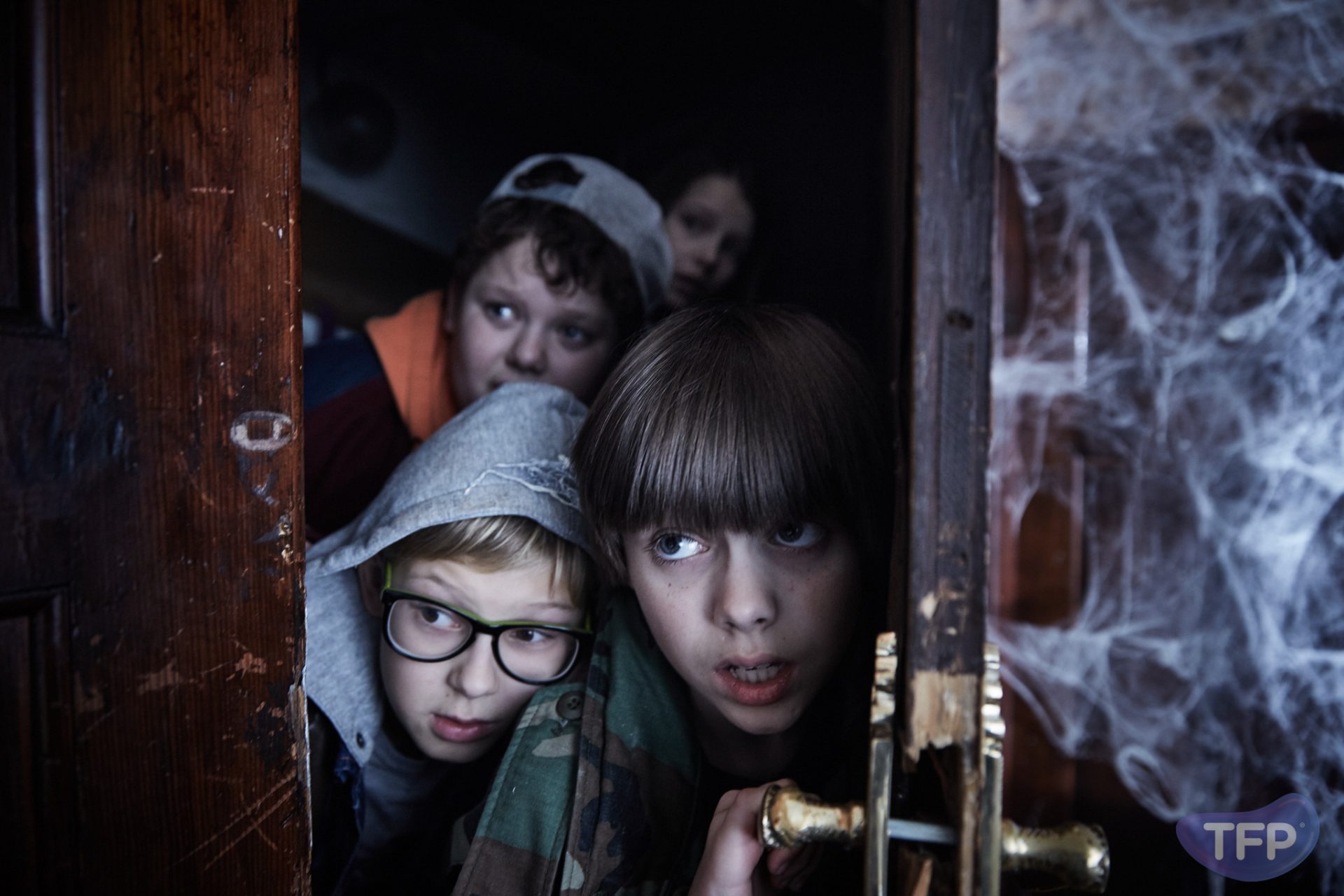 Kadr z filmu przedstawiający dzieci otwierające stare drzwi