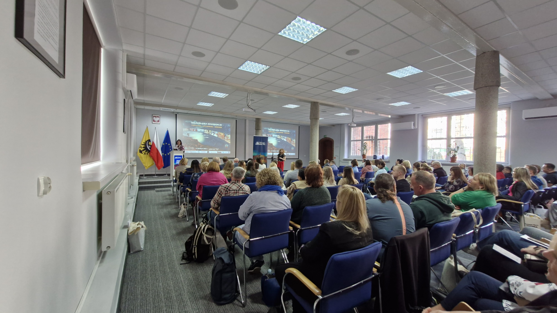 Zdjęcie audytorium wypełnionego ludźmi podczas konferencji