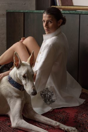 Zdjęcie modelki w białym stroju z psem pozującej do fotografii